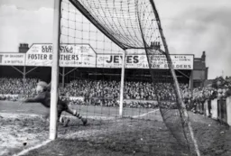 The goalkeeper is unable to save Payne's penalty