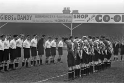 The teams line-up to pay respect to Club President Harry Arnold who had passed away during the week