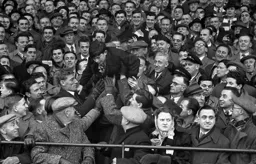 A young supporter is passed to the front
