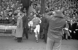 Arsenal skipper Joe Mercer leads out the Gunners