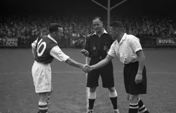 Bud Aherne shakes hands with Rotherham captain Gladstone Guest before the game, under the watchful eye of referee Mr Mann