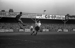 United keeper Ted Burgin jumps to it with Bernard Moore in close attendance