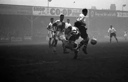 Jesse Pye with his back to the goal shields the ball from Ron Suart