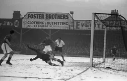 Tom Clinton behind the keeper is about to turn the ball into his own net under pressure from Jesse Pye