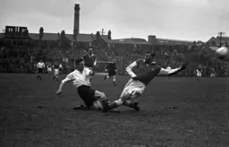 Bernard Moore shoots despite the attention of Argyle`s burly centre half Jack Chisholm