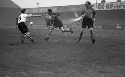 Leeds keeper John Scott gathers the ball as Bernard Moore rushes in