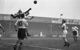 Rovers keeper Reg Elvey punches clear under pressure from Bernard Moore