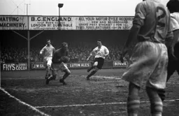 Bert Trautmann gathers the ball as Mike Cullen closes in
