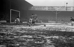 A loose ball in the Bolton penalty area with Gordon Turner closing in