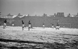 A snowbound pitch with a packed Kenilworth Road end terrace in the background