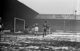 Bolton keeper Stan Hanson falls on the ball to thwart Gordon Turner