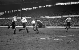 Bert Mitchell rushes in but Saints keeper John Christie gathers the ball in time