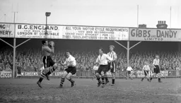 Brentford keeper Reg Newton controls the ball as Mike Cullen charges in