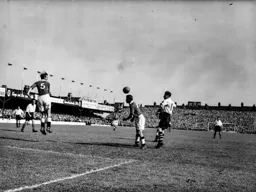 Bert Mitchell watches as Tom Kiley heads the ball clear