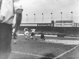 Andy Malcolm clears the ball away from Gordon Turner