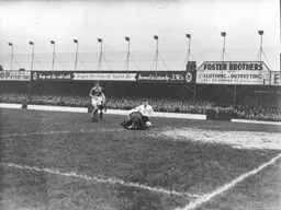 Ernie Gregory has hold of the ball as Bernard Moore slides in