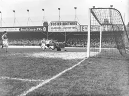 Bernard Moore gets past Malcolm Allison but Ernie Gregory pushes the ball away