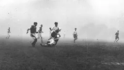 Gordon Turner is tackled on the edge of the penalty area as Kenilworth Road is shrouded in dense fog