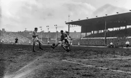 Bill Robertson races from his goal to tackle Gordon Turner