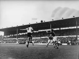 Gordon Turner heads the ball across the penalty area
