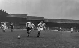 Peter MacEwen sticks his tongue out as he chases for the ball with Ken Thomson