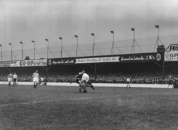 Stoke keeper Bill Robertson feels the full force of Peter MacEwen`s challenge. But the flag is up for offside.