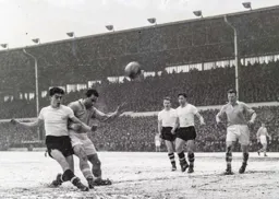 Gordon Turner tangles with Roy Paul as he attempts a shot at goal