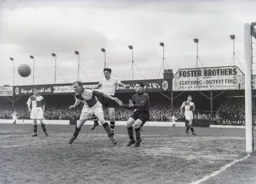 Ray Warren heads the ball clear as Gordon Turner waits to pounce