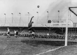 Wolves keeper Bert Williams leaps high but the ball flew over the bar