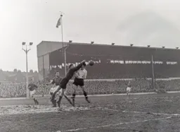 Jimmy O`Neill punches the ball away from the head of Gordon Turner