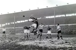 Gordon Turner watches Jimmy O`Neill punch the ball clear