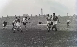Reg Pearce shoots through a crowd of players