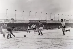 The ball rolls through to Ray Wood as Bob Morton and Gordon Turner chase in vain