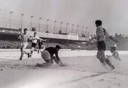 The ball is lost in the snow as Gordon Turner looks to pounce