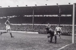 Norman Uprichard clutches the ball as Jimmy Adam rushes in