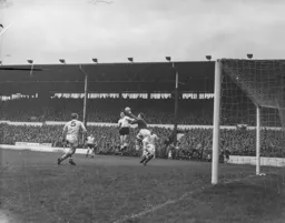 John Savage punches the ball away under pressure from Gordon Turner