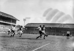 Harry Clarke plays the ball away from Reg Pearce