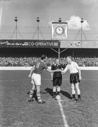 Syd Owen, Leeds captain John Charles and referee Mr Barradell meet pre match in front of the new SKF clock