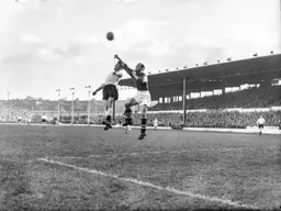 Roy Davies jumps for header but Jim Sanders punches the ball away