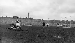 Bob Morton falls to the ground as Jimmy Dugdale shapes to clear the ball
