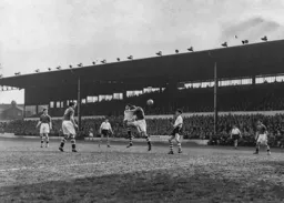 Despite a robust challenge Allan Brown manages to send a header towards goal