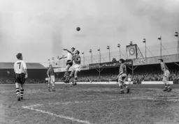 Allan Brown out jumps Bryan Edwards to send a header skywards