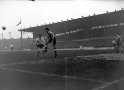 Gordon Turner looks on as Bob Stokoe heads the ball clear