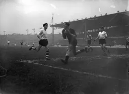 United`s Ronnie Simpson holds on to the ball as Gordon Turner is on the charge