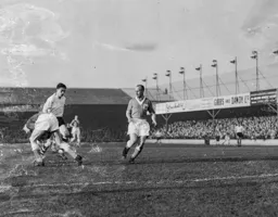 Chic Thomson races out of his goal to repel this attack by Gordon Turner