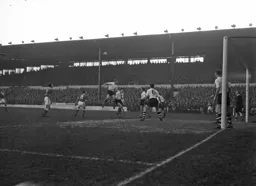 Syd Owen heads the ball out of danger following a corner kick