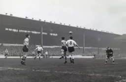 The referee keeps a close watch as Gordon Turner and Eddie Stuart compete for the ball