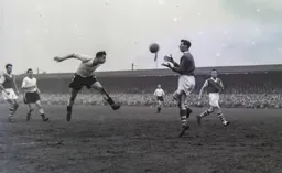 Bob Morton strains every neck musscle to get in this header but Roy Bailey makes the save