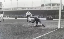 Albert Dunlop clutches the ball with Tony Gregory hovering