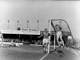 Liverpool keeper Jim Furnell swings from the netting watched by Ronnie Moran